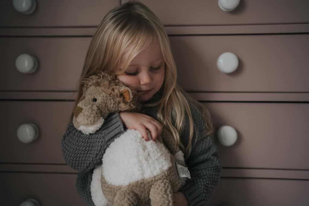 A child holding a soft toy