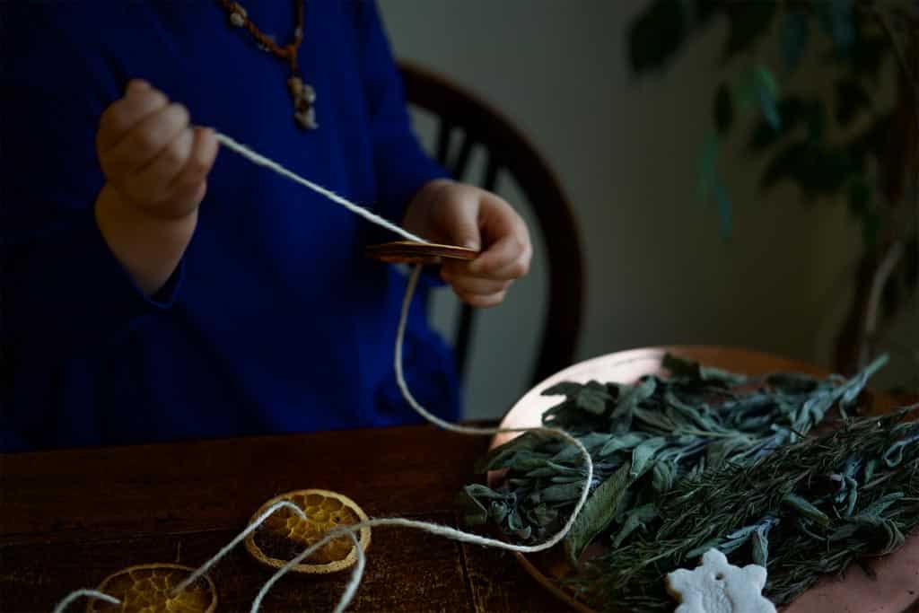 A child threading with twine