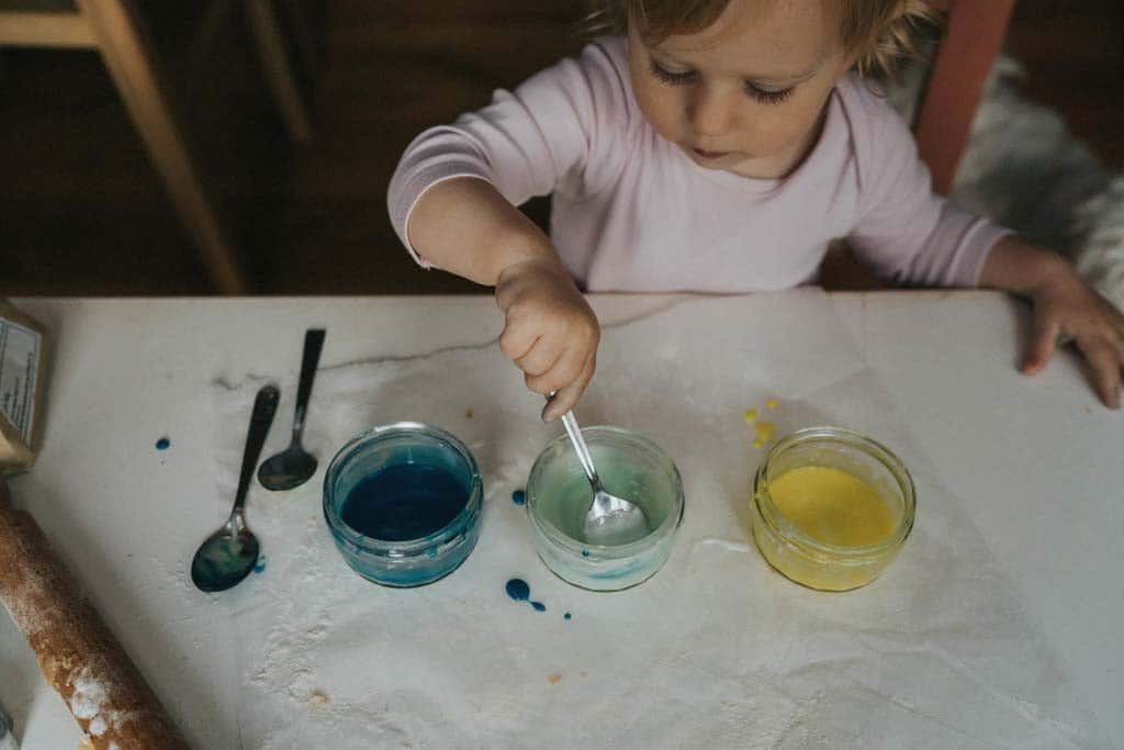 A child choosing between bowls of icing