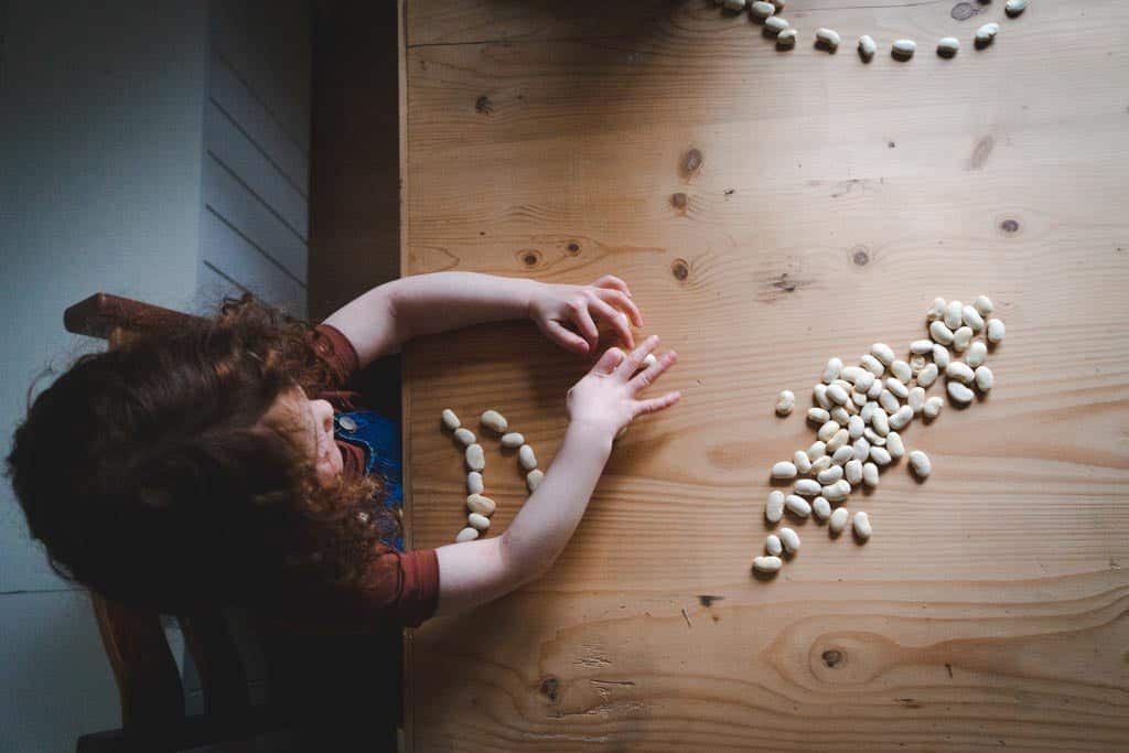 A child counting with beans, an example of concrete materials