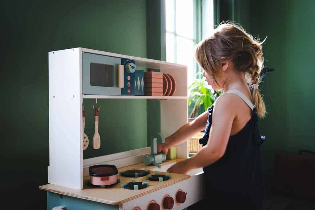 Girl playing with a play kitchen