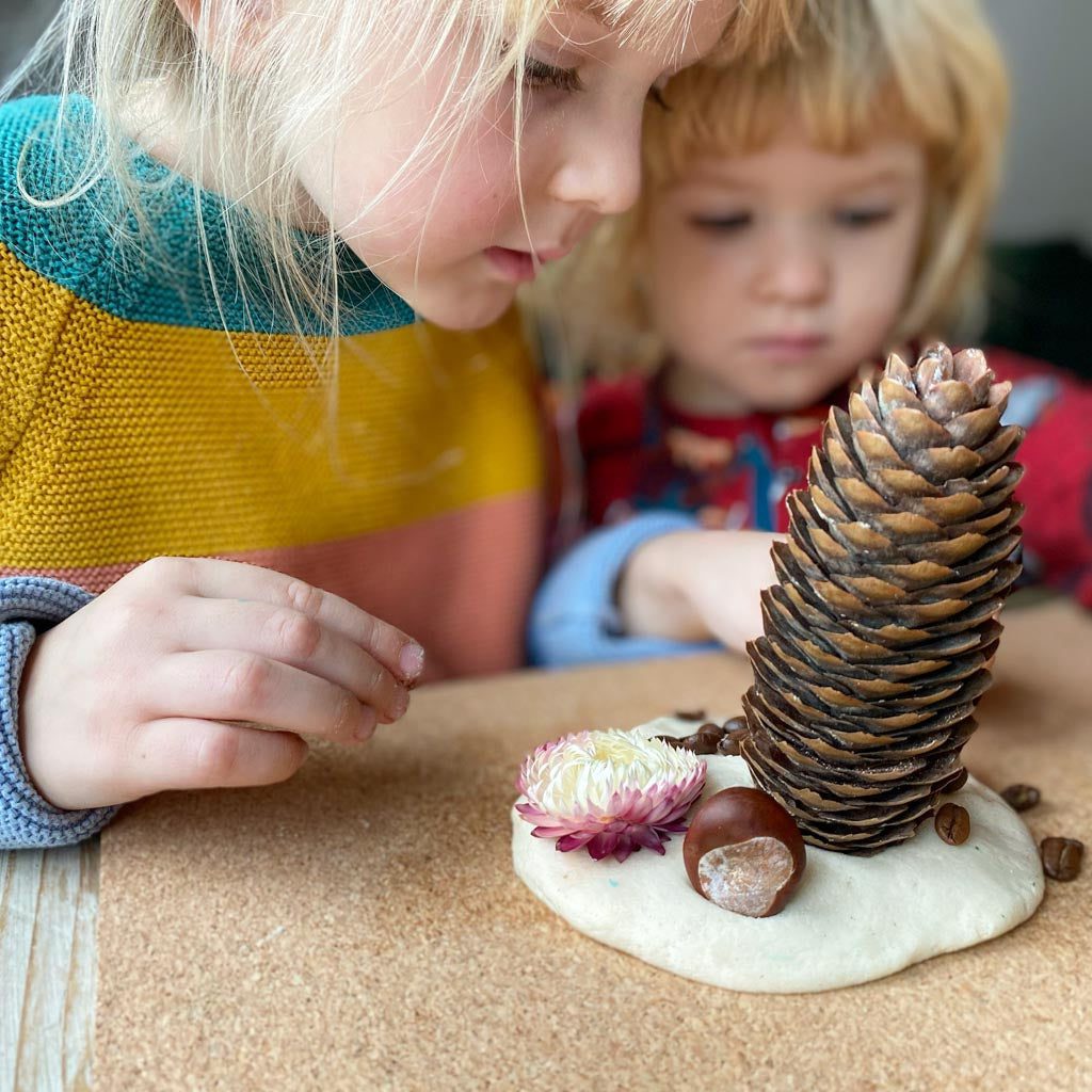 Pine cones and other loose-part natural materials stuck into playdough