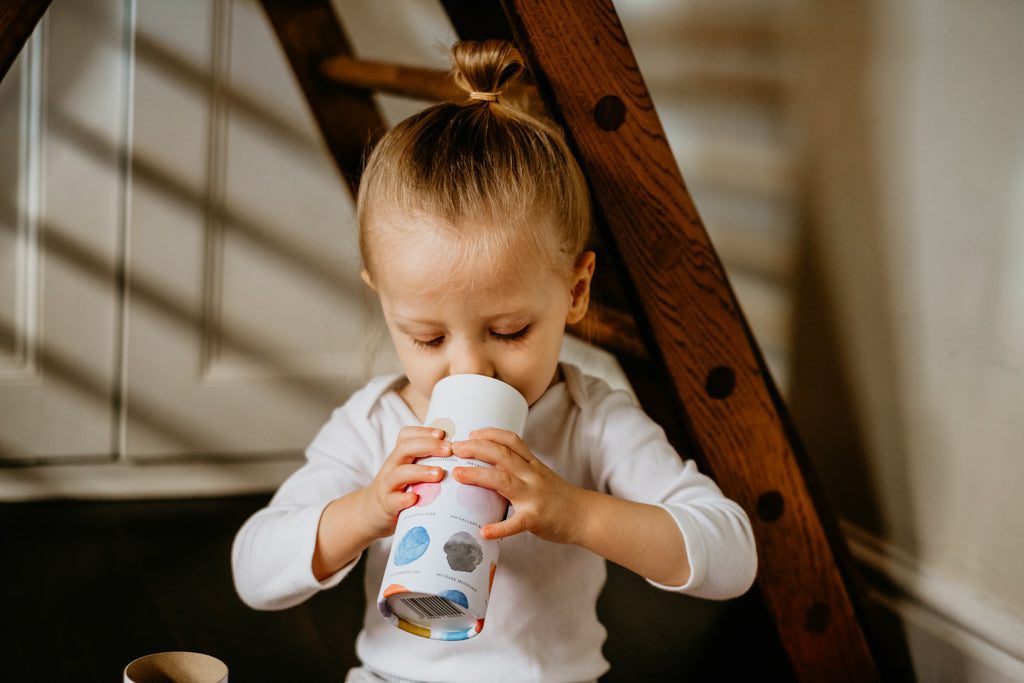 A child looking inside a cardboard tube