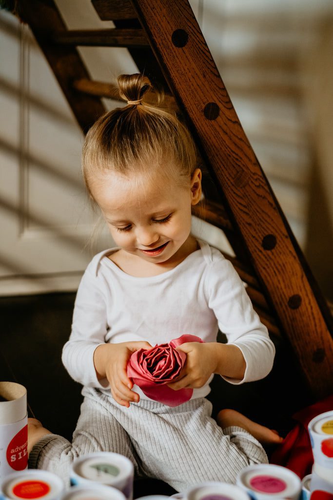 A child rolling up a playsilk