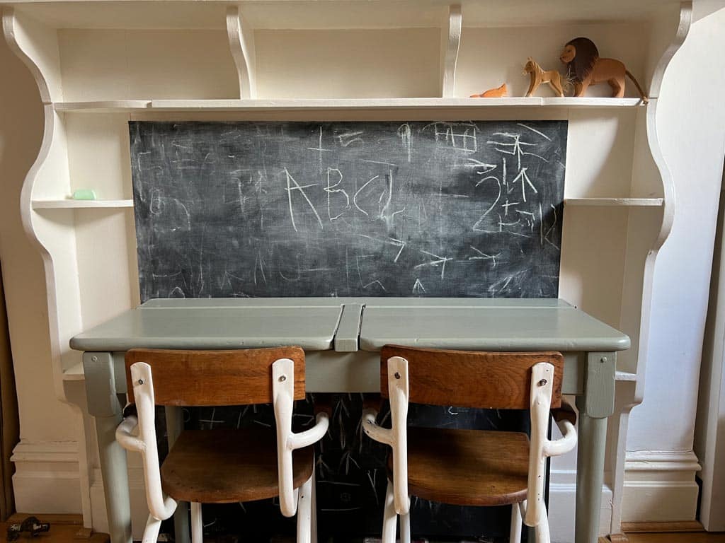 A desk and blackboard make a simple writing corner.