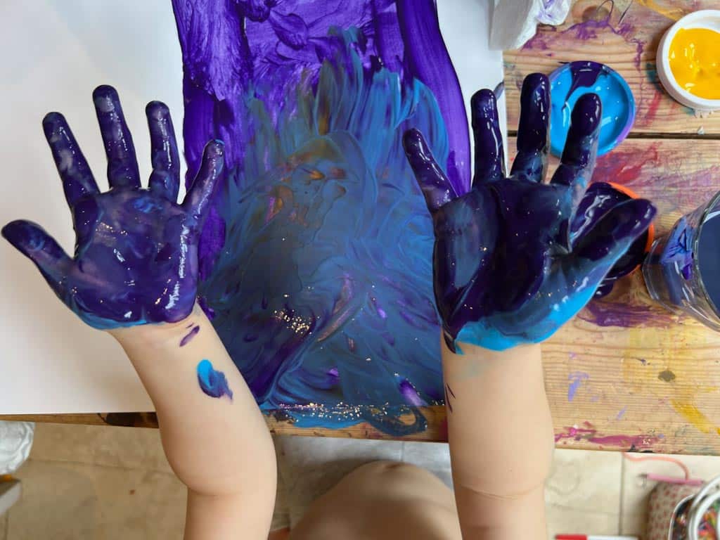 Process art - a child painting her hands