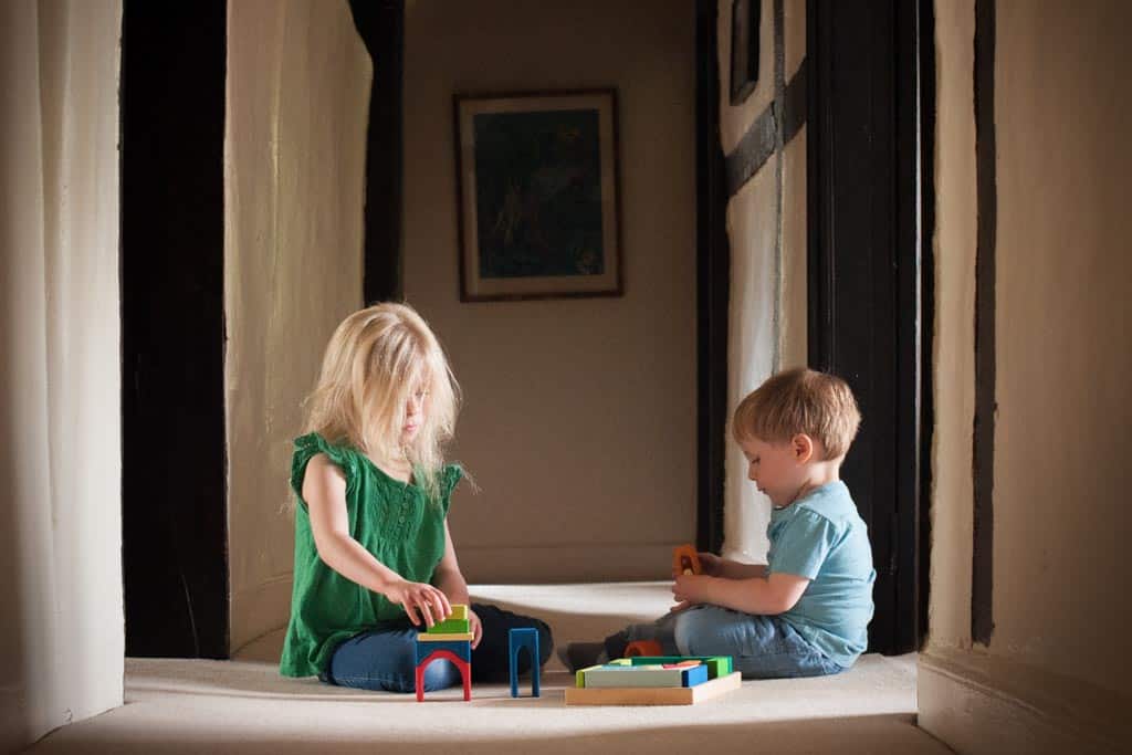 Two children playing in parallel, with a set of wooden blocks